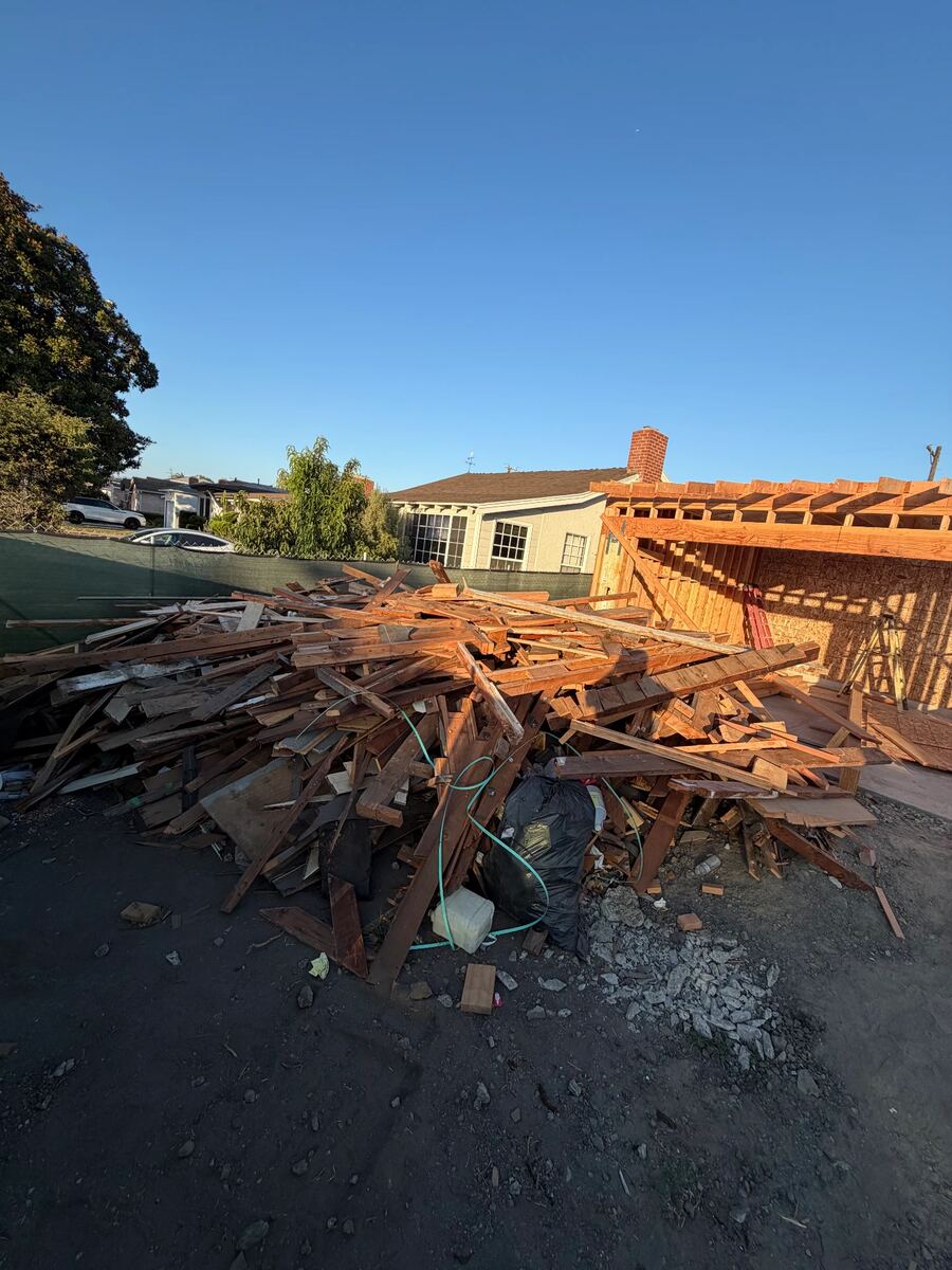 Job photo: Demolition lumber stacked beside a framed structure for haul-away